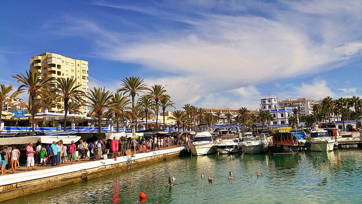 Paseantes en el mercadillo del puerto deportivo de Estepona, vecina de Manilva, en 2014