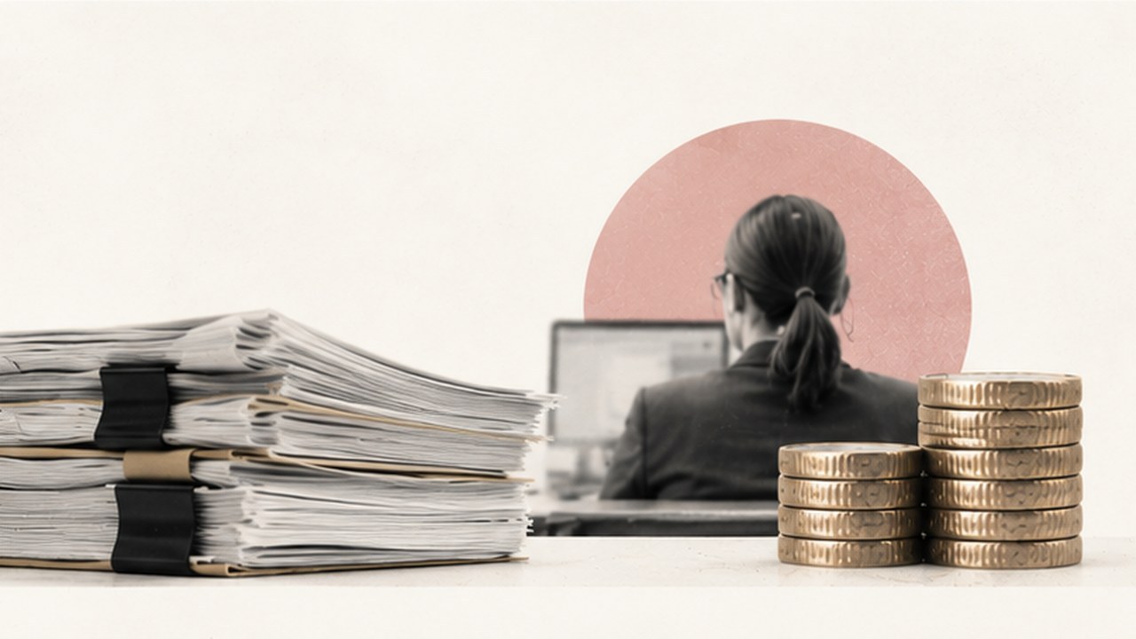 Una empleada pública ante su ordenador, de espaldas, junto a pilas de expedientes y de monedas.