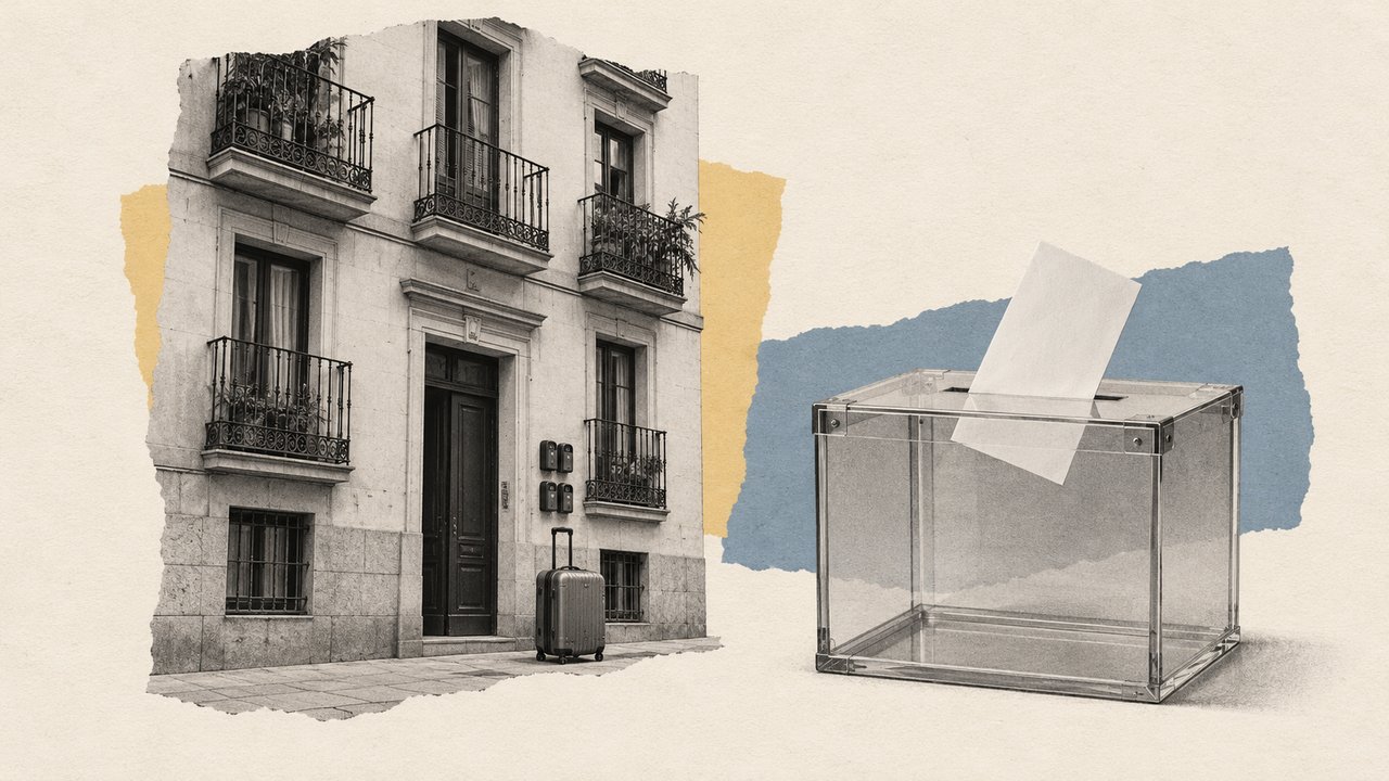 Un edificio de viviendas con una maleta en el portal y una urna con una papeleta.